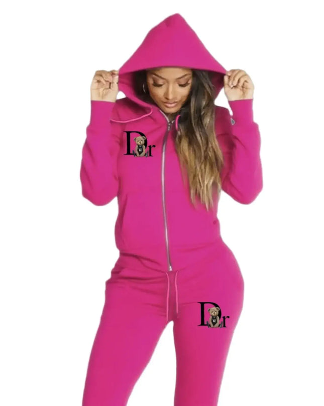 Person wearing a pink hoodie and pants with a logo on a gray background