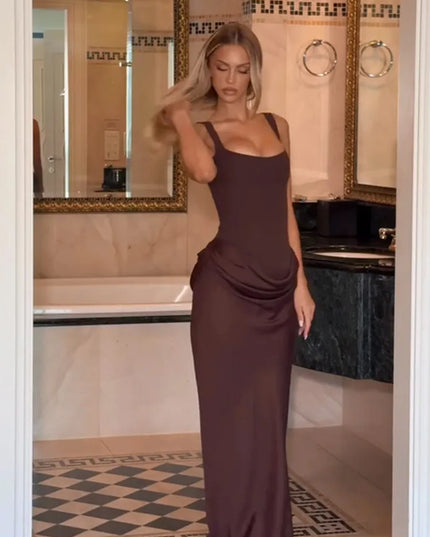 Brown pleated maxi dress featuring a square neck and sleeveless design, showcased in an elegant bathroom setting.