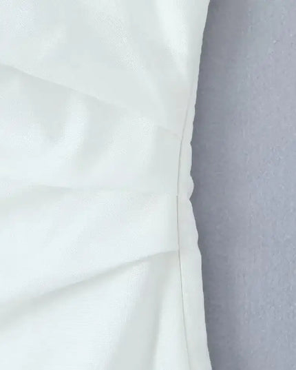 close-up of the fabric texture of a white cotton linen summer dress, showcasing its quality and design details.