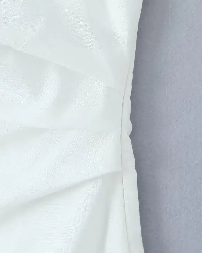 close-up of the fabric texture of a white cotton linen summer dress, showcasing its quality and design details.