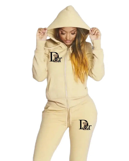 Person wearing a beige tracksuit with a logo on a gray background
