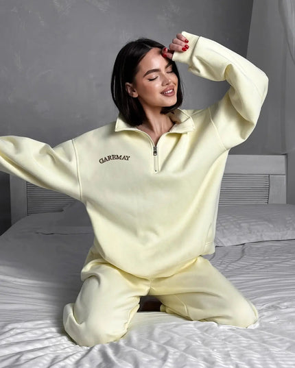Person wearing a light yellow 'GAREMAY' loungewear set on a bed.