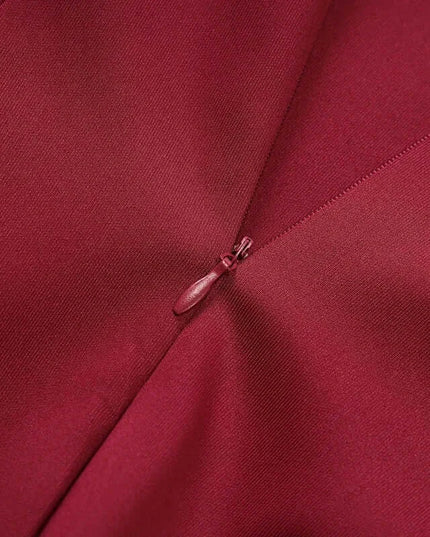 Close-up of the elegant fabric and zipper detail of an off shoulder mini dress party outfit in deep burgundy color.