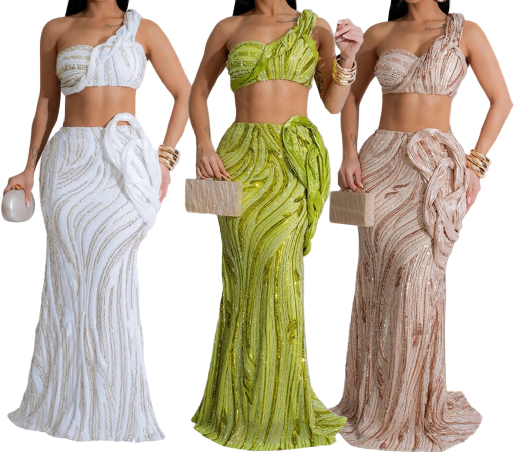 Three women wearing elegant dresses in white, green, and beige.