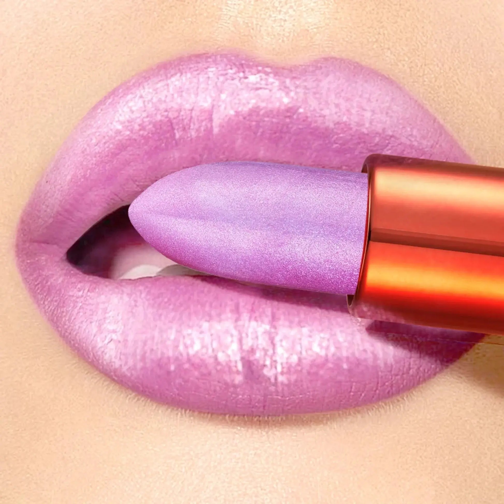 Purple lipstick being applied to a lip with a beige background