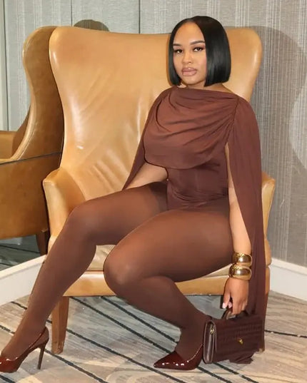 Woman in a brown outfit sitting on a leather chair in an indoor setting