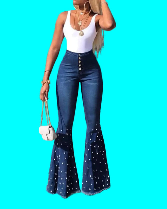 Woman wearing blue flared jeans and a white top on a street.