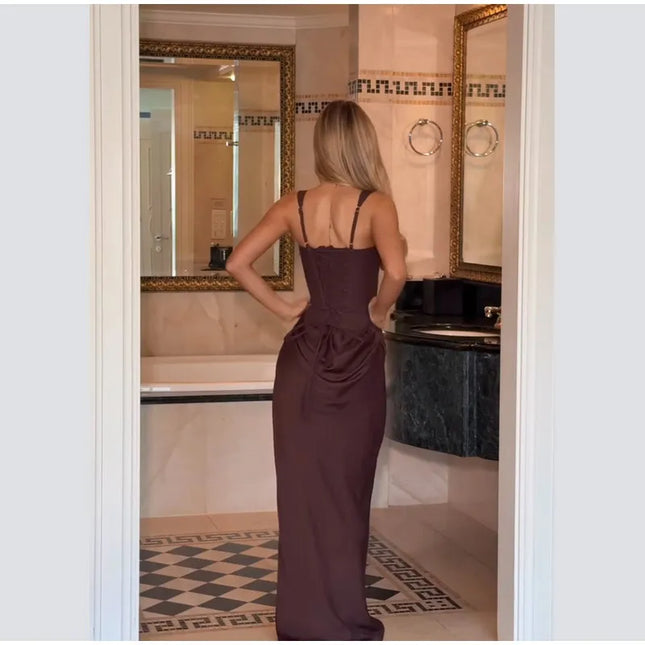 Brown pleated maxi dress worn by a woman from the back, showcasing its elegant design in a stylish bathroom setting.