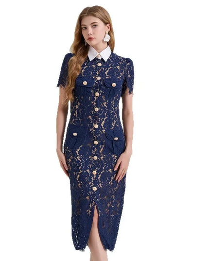 Woman wearing a navy lace dress with gold buttons on a white background
