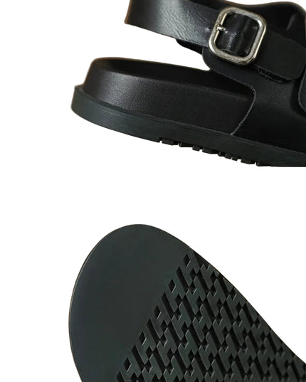 Black sandal with a buckle on a beige background