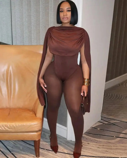 Woman in a brown outfit standing in a room with a beige sofa.