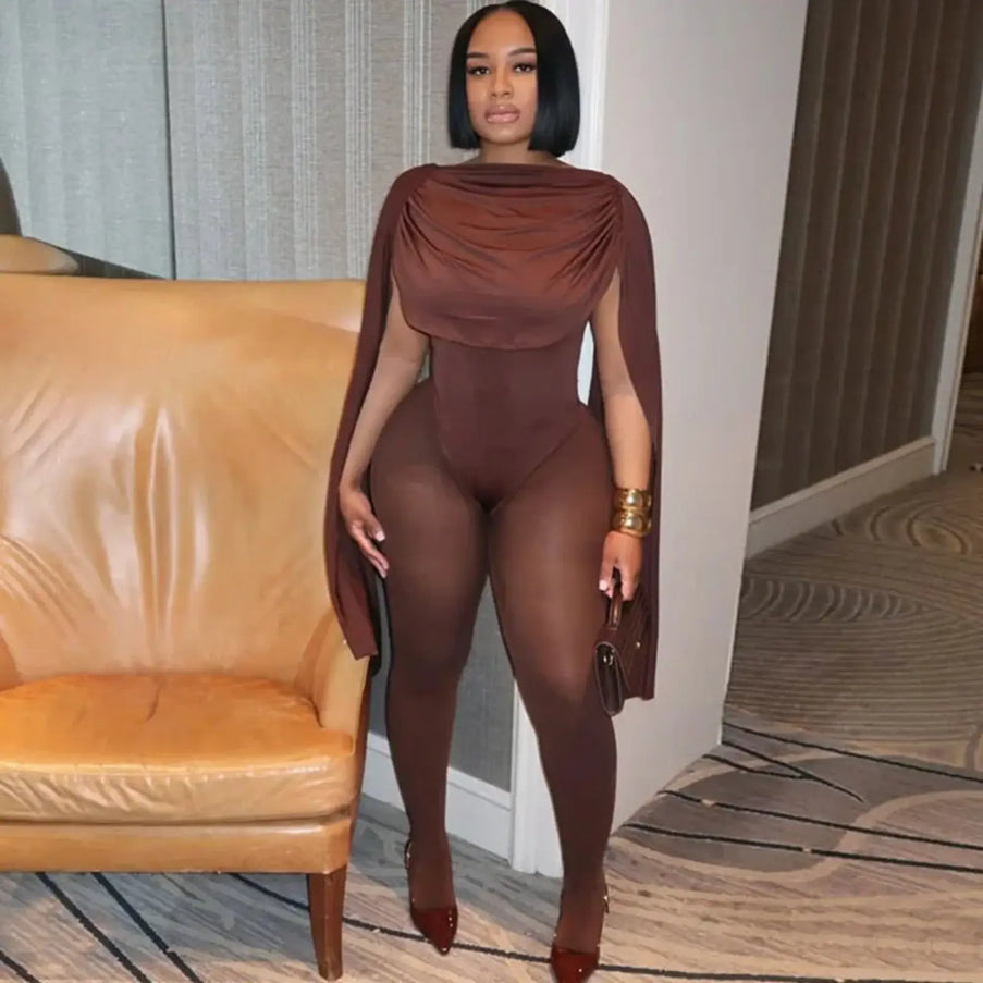 Woman in a brown outfit standing in a room with a beige sofa.