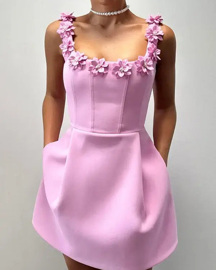 Pink dress with floral straps on a plain background