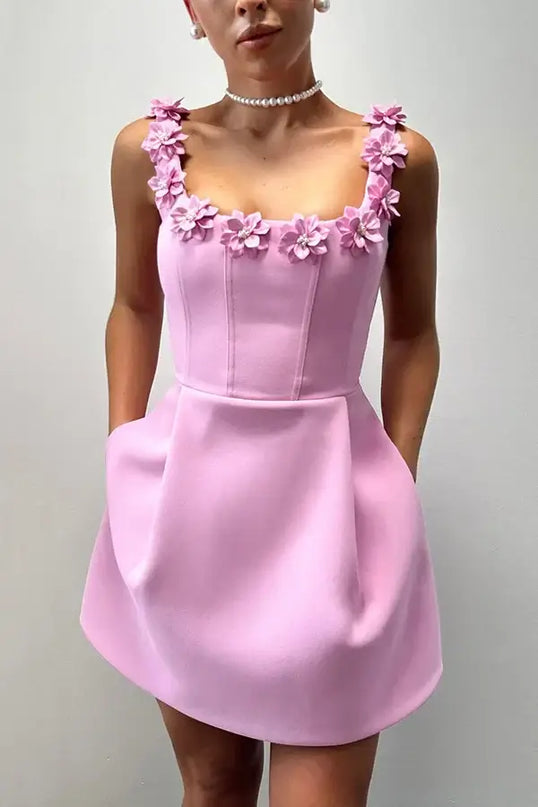 Pink dress with floral straps on a plain background