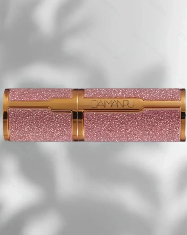Pink glittery lipstick with gold accents on a light gray background