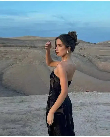 Oligai one shoulder elegant dress worn by a model in a scenic outdoor setting showcasing a black mesh bodycon design.