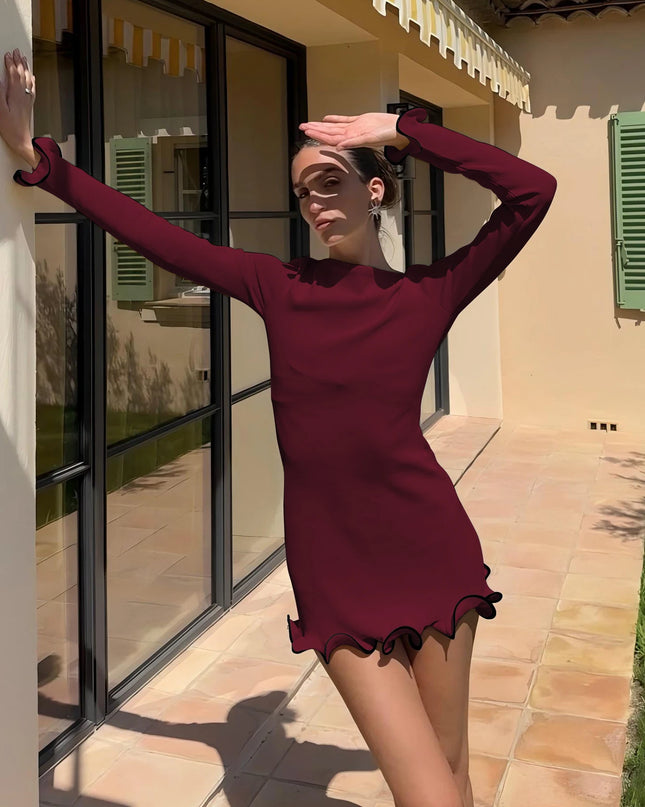 Womens bodycon mini dress in burgundy with long sleeves and ruffled hem, showcased outdoors by a model.