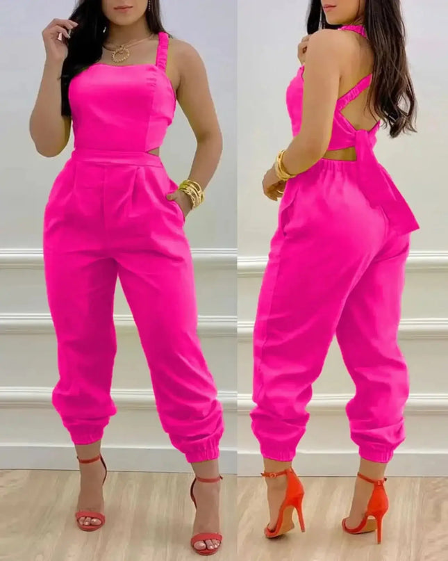 Woman wearing a bright pink jumpsuit with a white wall background