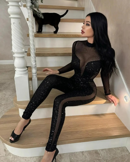 Woman in a black sequin outfit sitting on a staircase with a black cat.