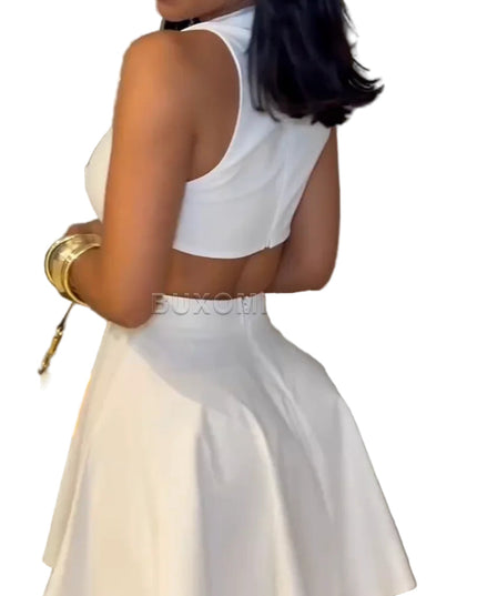 Woman in a white dress holding a yellow handbag against a gray wall.