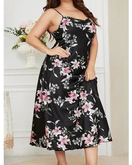 Woman wearing a black floral dress in a room with white walls and a vase of flowers.