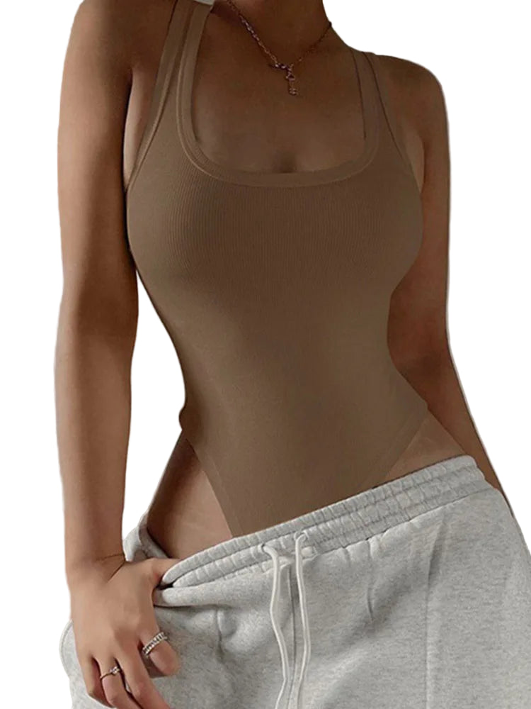 Person wearing a beige tank top and gray sweatpants against a neutral background