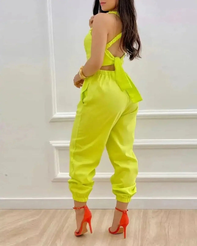 Person wearing a bright yellow outfit with orange heels against a white wall.