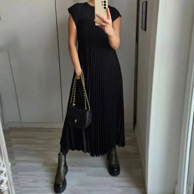 Women’s elegant sleeveless dress with pockets in black, pleated design and stylish handbag.