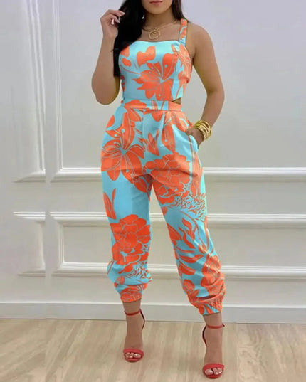 Woman wearing a colorful floral jumpsuit against a white wall.