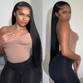 Woman posing in a beige top and black leggings against a plain background