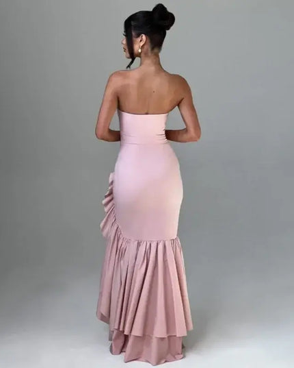 Sexy strapless summer dress showcased from the back, highlighting its elegant design and ruffled hem in a soft pink color.