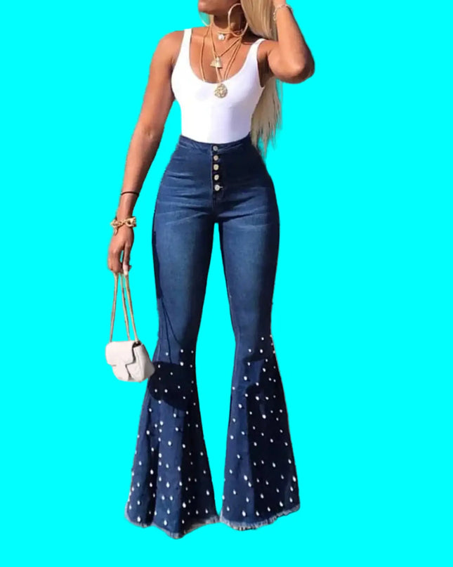 Woman wearing blue flared jeans and a white top on a city street.