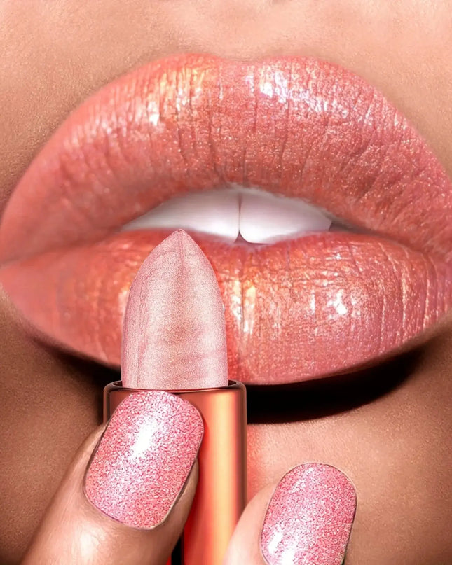 Close-up of a hand holding a pink lipstick against a blurred background