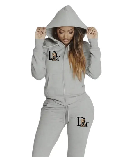 Person wearing a gray hoodie and pants with a logo on a gradient background