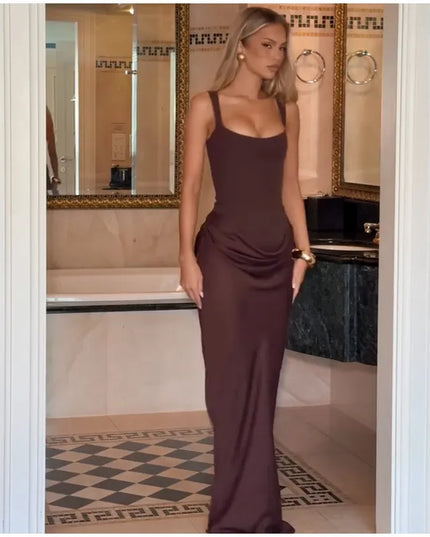 Brown pleated maxi dress worn by a model, showcasing its elegant square neck and sleeveless design.