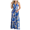 Women in a tropical print halter backless maxi dress with deep V neckline, perfect beachwear for summer.