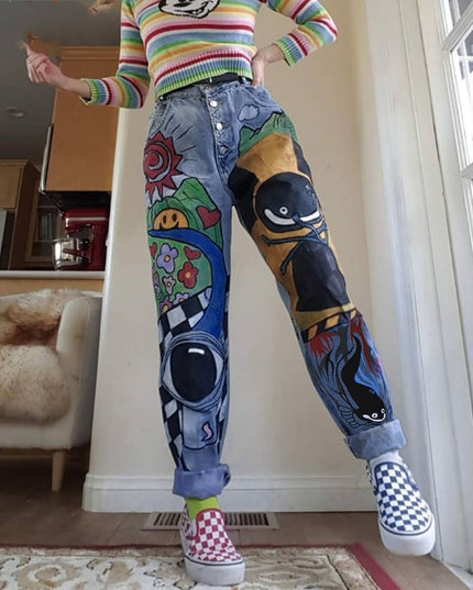 Person wearing colorful sweater and jeans with cartoon designs in a room.