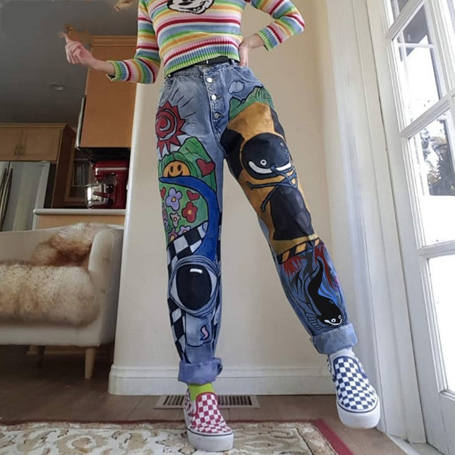 Person wearing colorful sweater and jeans with cartoon designs in a room.