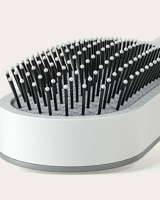 Pet grooming brush with black and white bristles on a light gray background