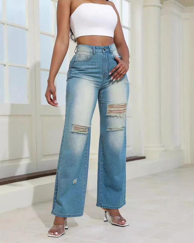 Person wearing high-waisted, distressed blue jeans and a white top indoors.