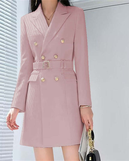 Pink blazer with gold buttons worn by a person, standing against a light background.