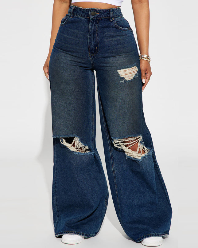 Wide-leg jeans with distressed details on a white background